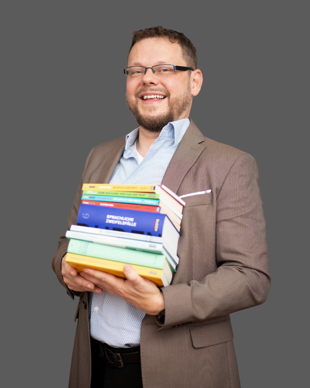 Sascha Foto eines Mannes im mittleren Alter mit einem Stapel Bücher