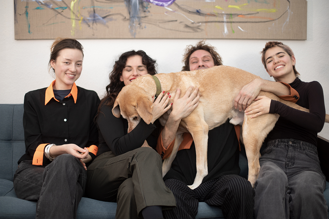 Emily, Marielle, Micha und Jordis sowie Labrador Mateo aus dem Team 2komma8 auf dem Agentursofa